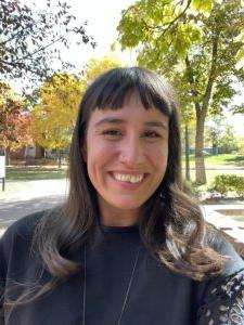 Woman, Mariah Master, Smiling in a black shirt. Background a picture of a park.