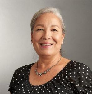 Woman, smiling, with hair in pulled back and in a black top